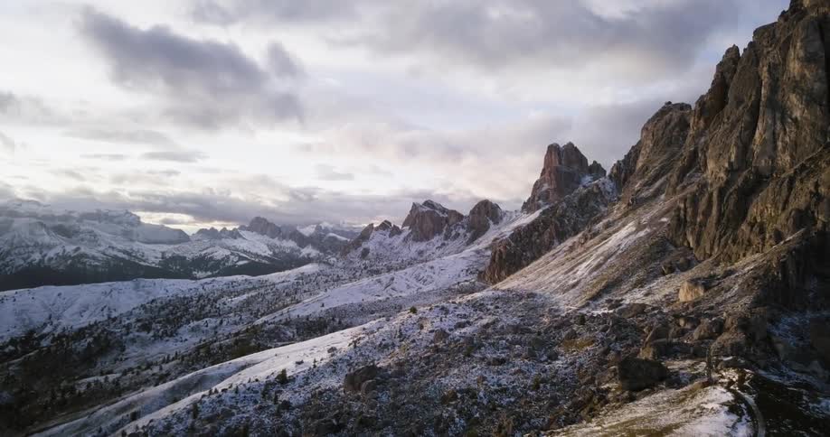 Clouds hover over a snow-covered mountain range