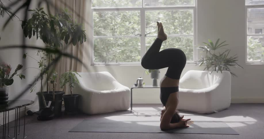 A woman balances on her head while practicing yoga