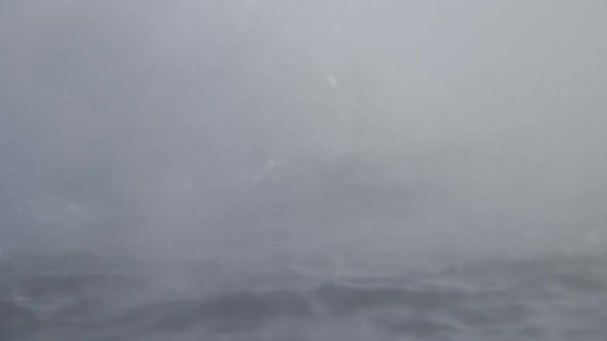 Thick, billowing mist rises from the turbulent, churning water at the base of a powerful waterfall