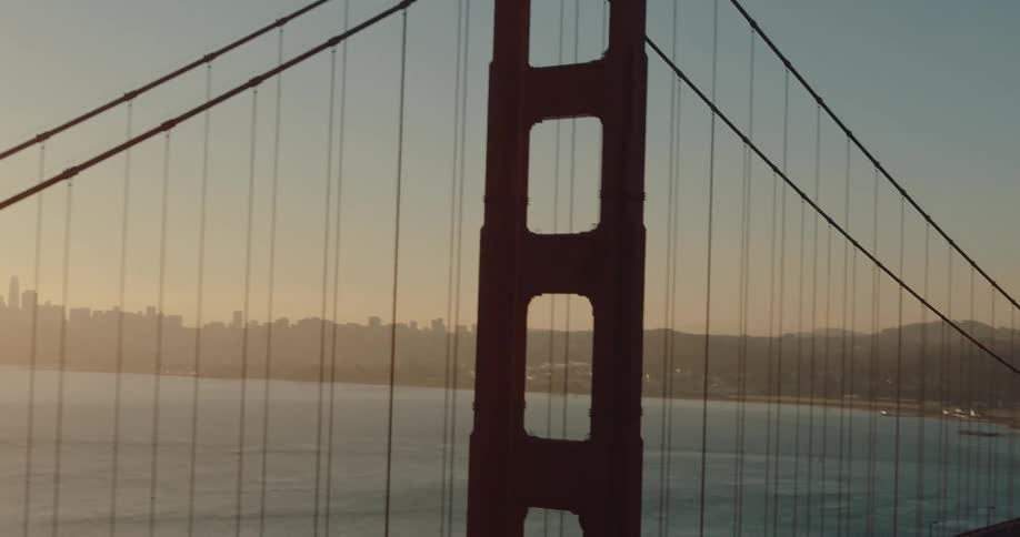 A slow tilt-down reveals the iconic Golden Gate Bridge and the San Francisco skyline at sunrise