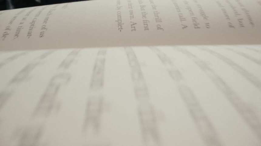 A very close-up macro shot slowly pans across the text on the page of an open book