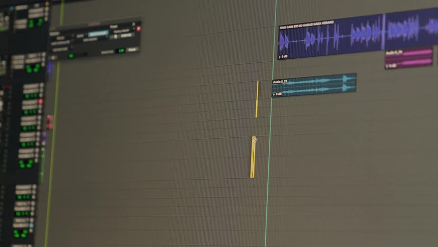 Close-up of a digital audio workstation timeline with the playhead moving across colorful audio waveforms