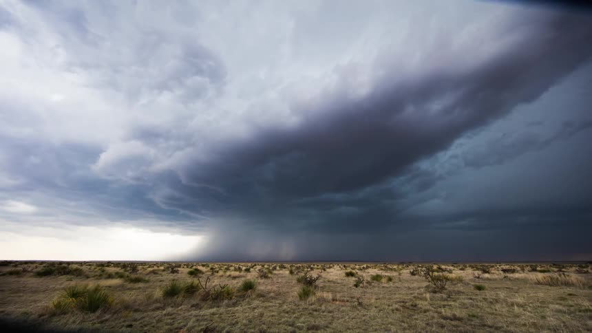 Storm clouds form and move across a plain