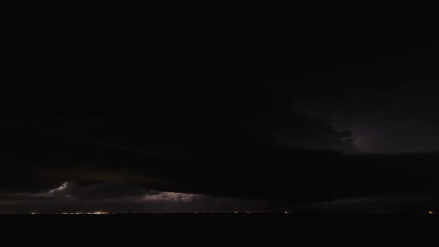 Lightning flashes in moving storm clouds at night