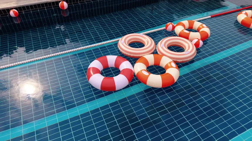 Colorful red, orange, and white inflatable rings gently float in a sunlit swimming pool with blue tiles