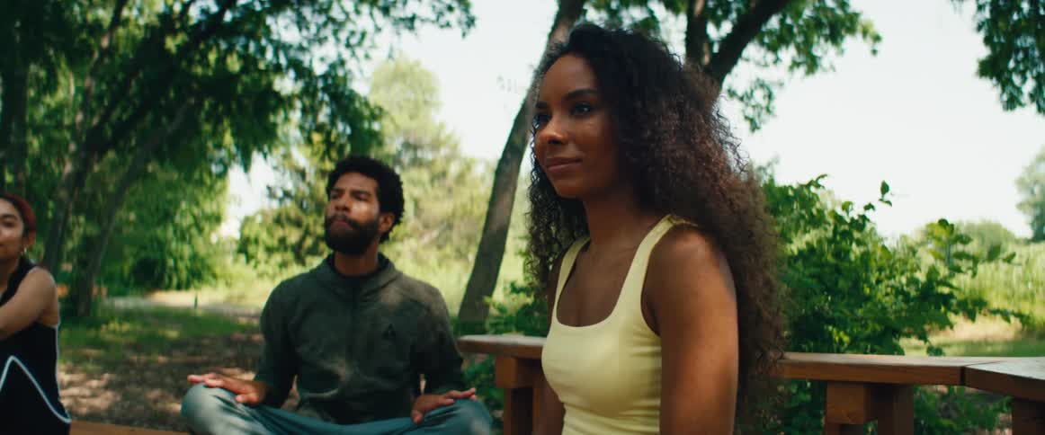 A man and woman laugh and applaud together after finishing a peaceful outdoor meditation session