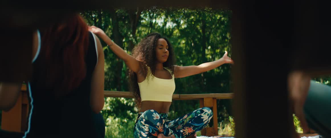 Two women practice a relaxing yoga and meditation routine together on a peaceful outdoor patio surrounded by nature
