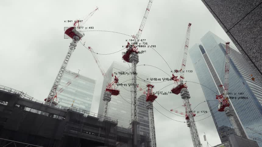 Digital data overlay shows a network of interconnected smart cranes at a modern urban construction site