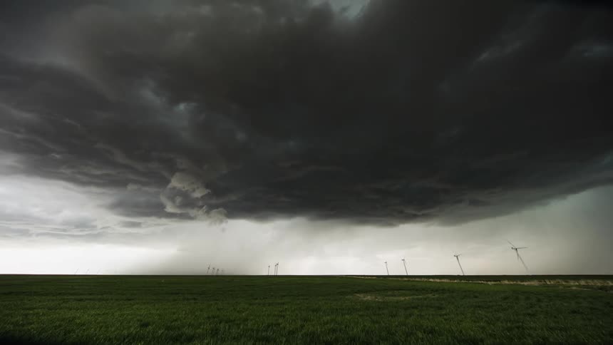 Storm clouds gather and darken over a field
