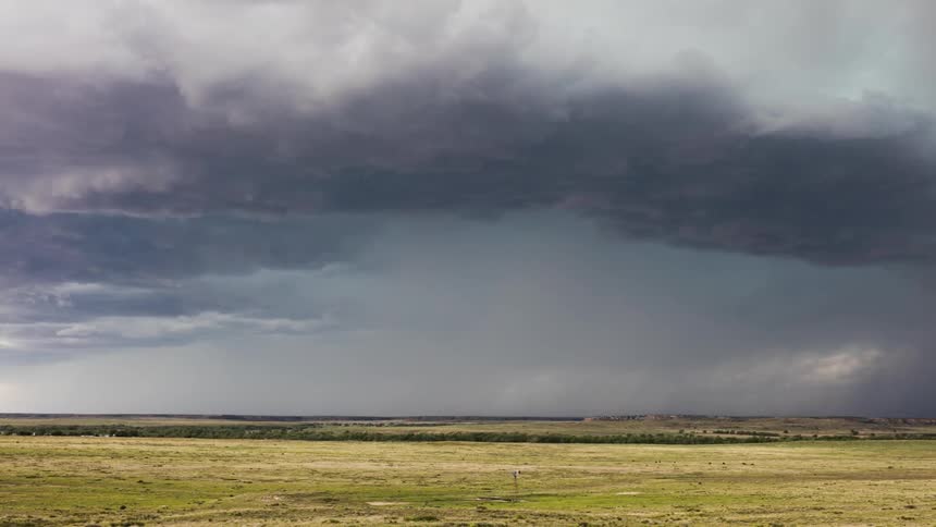 Storm clouds float over an open field