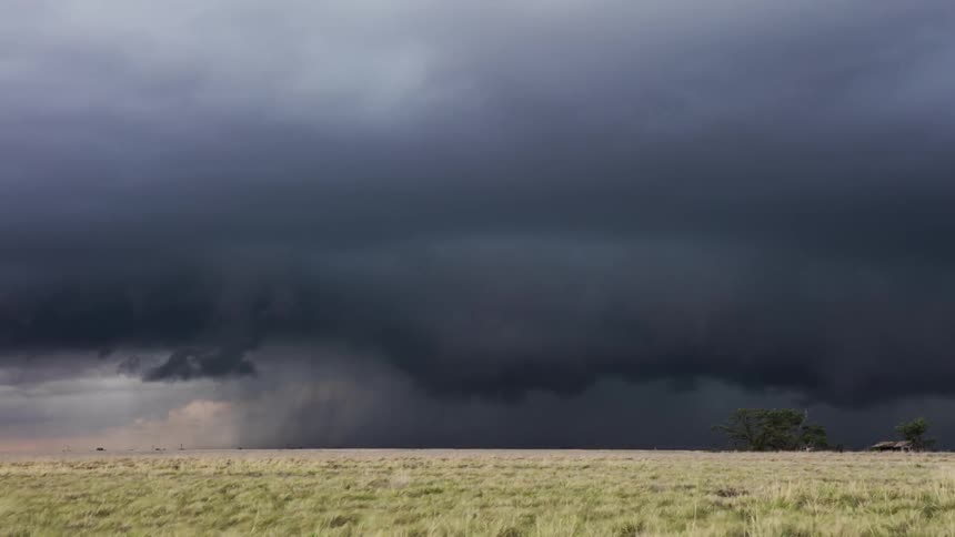Storm clouds form over a grassy field