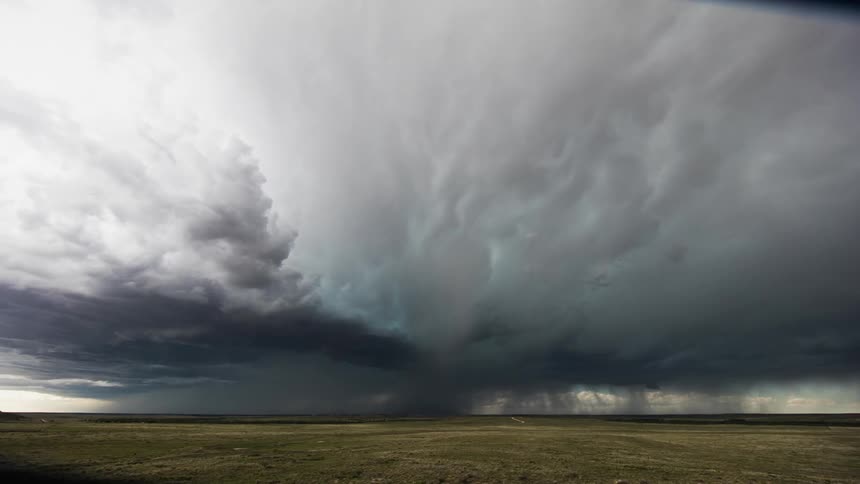 Storm clouds float over an open field