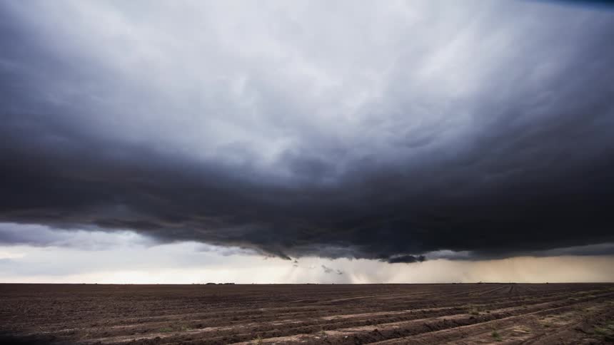Storm clouds form over an open field