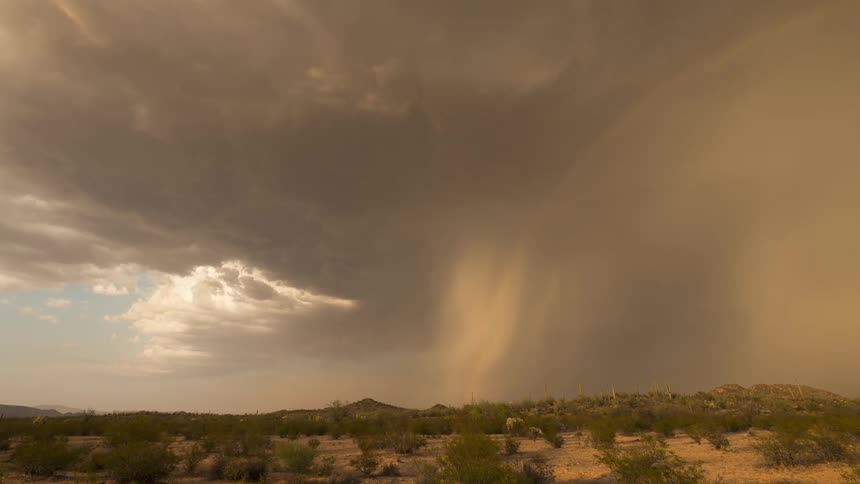 A powerful microburst unleashes rain over the desert as a beautiful double rainbow appears in this stunning timelapse