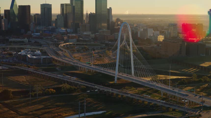 Aerial view of the iconic Margaret Hunt Hill Bridge with the Dallas, Texas skyline in the background at sunrise