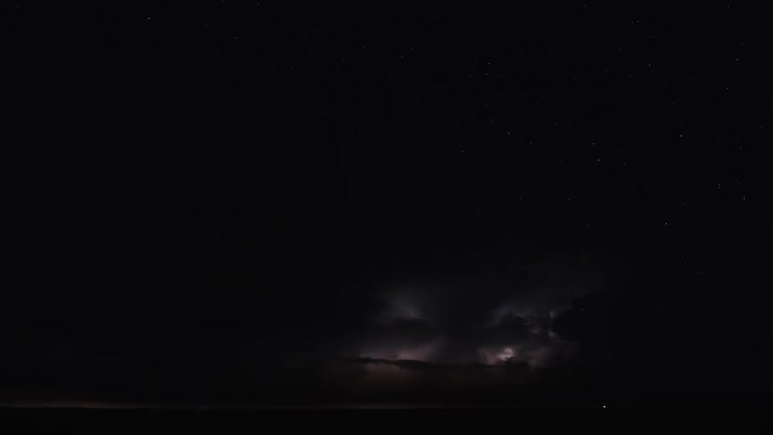 Lightning flashes in moving storm clouds at night