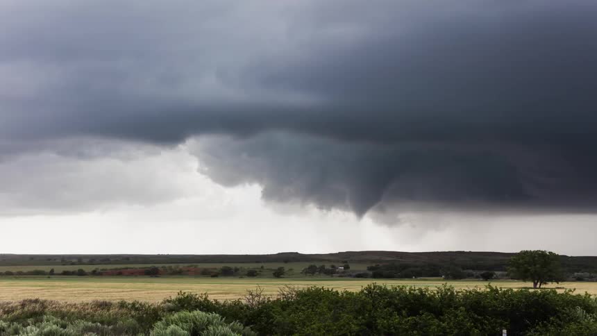 Storm clouds gather and circle over a field