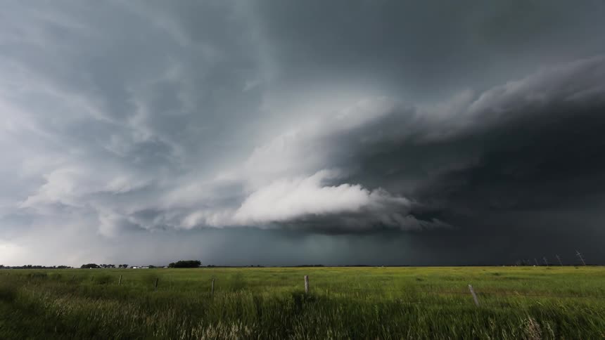 Storm clouds form over a grassy field