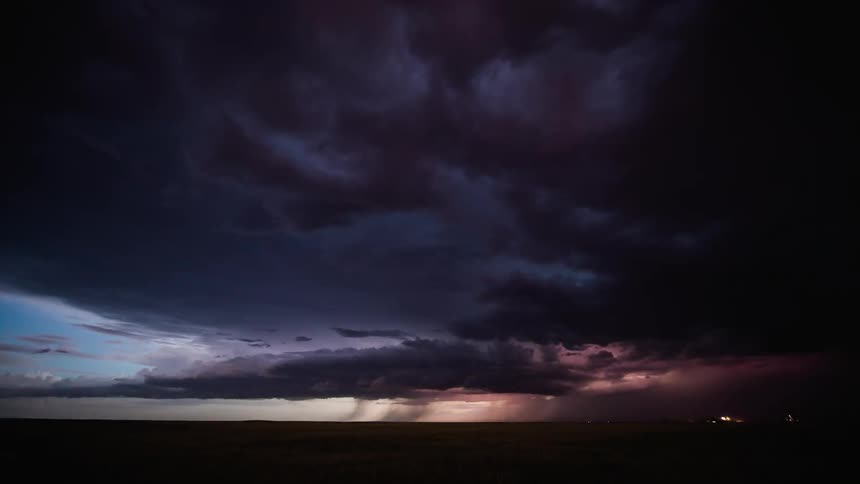 Lightning storm flashes over plains at sunset