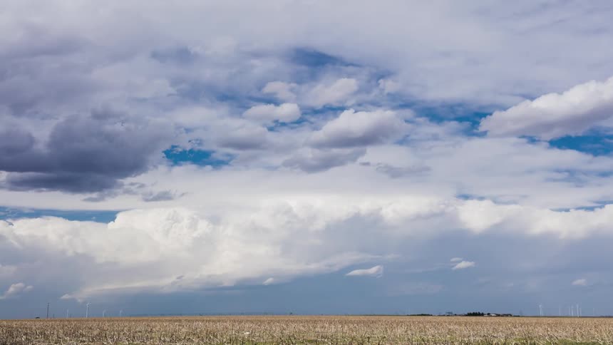 A long field has heavy clouds above