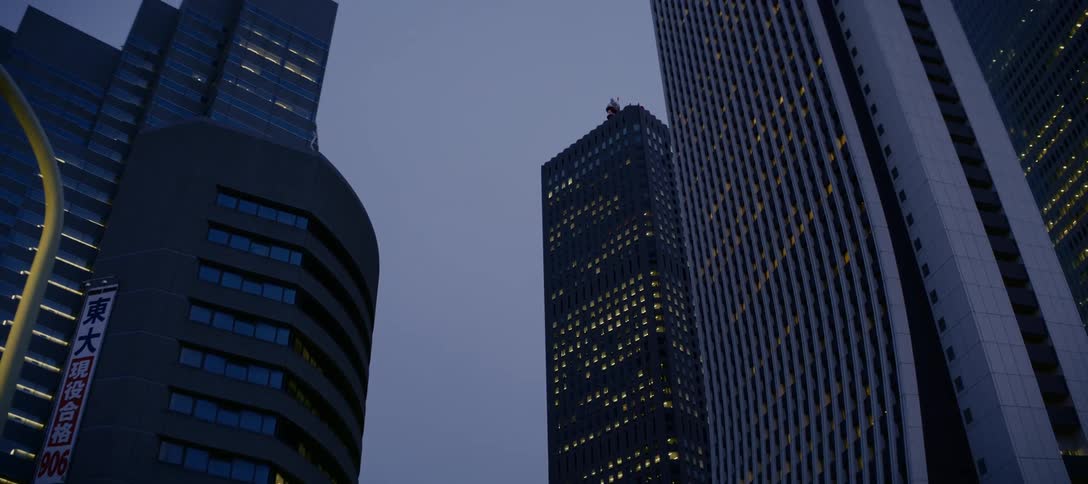 A cinematic low-angle pan reveals the impressive architecture of a city's financial district at twilight