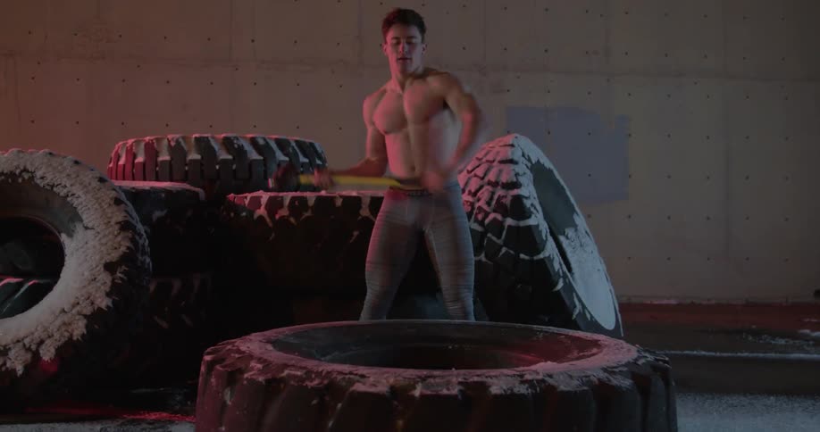A man is hammering a large tire