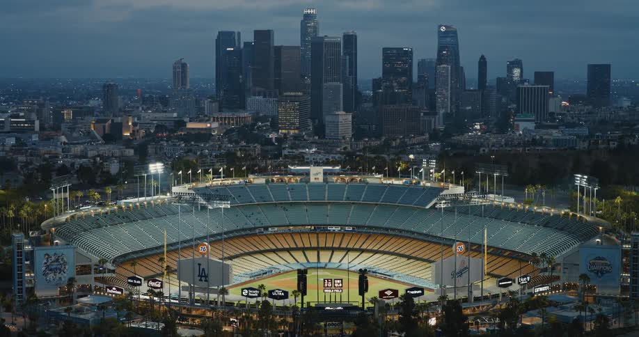 Epic aerial view of Dodger Stadium at twilight with the downtown Los Angeles skyline in the background