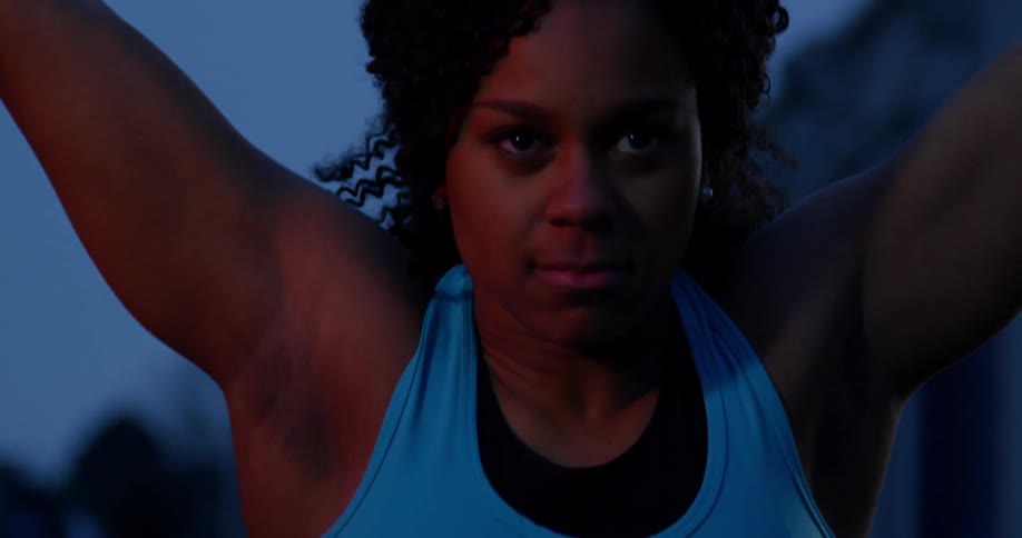 A woman is lifting weights outside