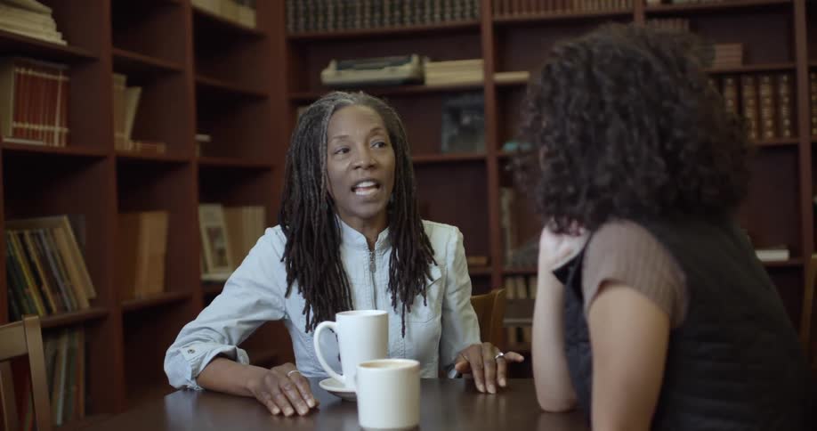 Two women chat over coffee in a coffee shop