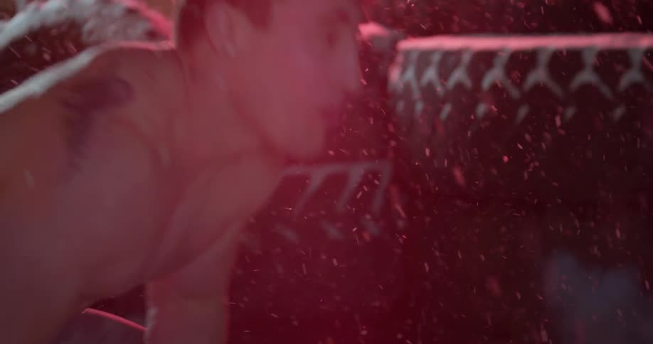 A man is using a weighted ball to workout with outside while it snows