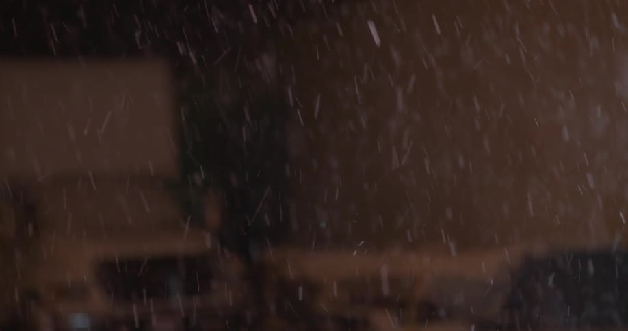 A male athlete is catching a weighted ball outside in the snow