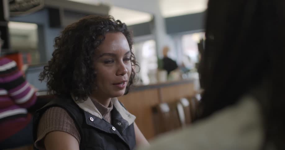 A woman talks with a friend in a cafe