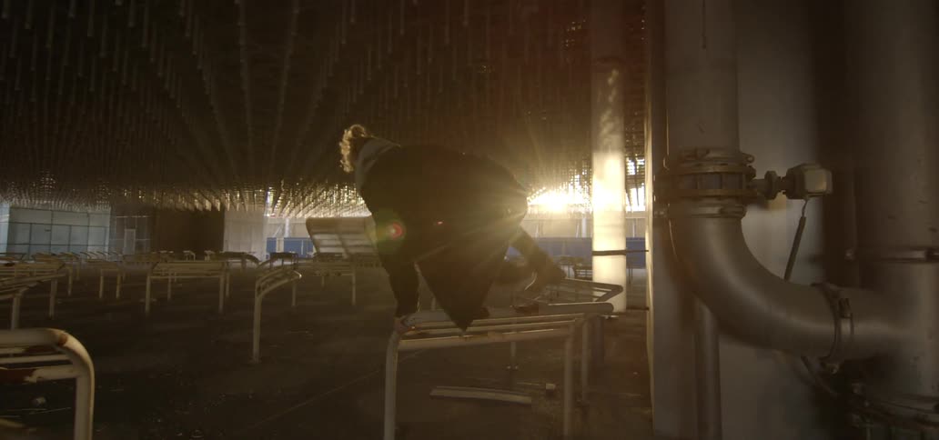 A young man is leaping over barriers in a building