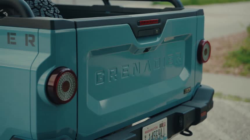 Close-up detail of the tailgate on a modern blue Ineos Grenadier Quartermaster pickup truck