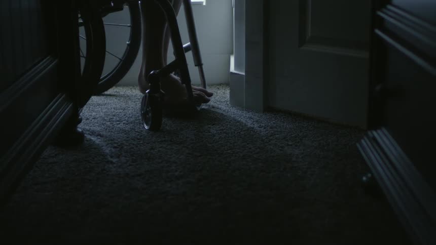 A person turns the corner in a wheelchair in the hall