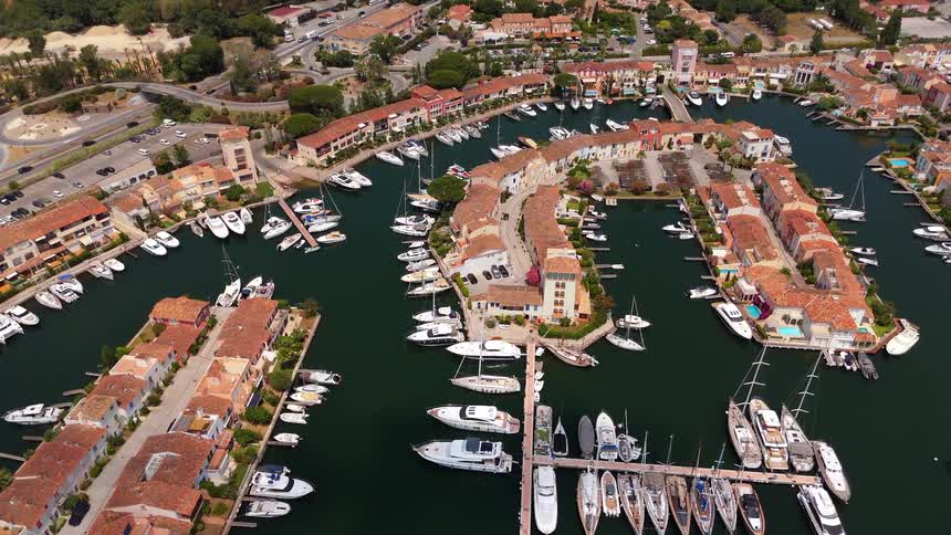 A stunning high-angle aerial view of a picturesque coastal town with a bustling marina full of luxury yachts and boats