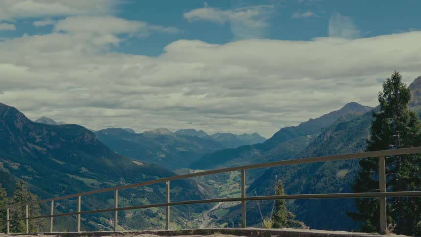 A breathtaking static view of a lush mountain valley seen from an overlook on a cloudy day