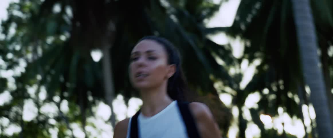 A terrified woman with a backpack runs for her life through a dark jungle at sunset, screaming in fear