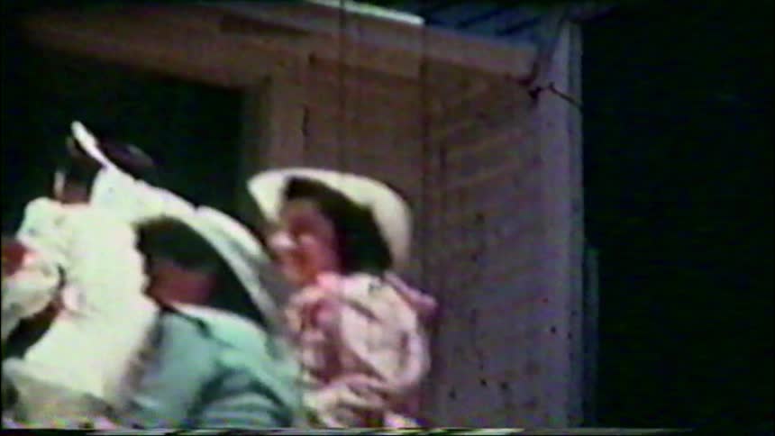 A bride, bridesmaid, and a little flower girl in hats pose with a bouquet in this vintage home movie from the 1940s