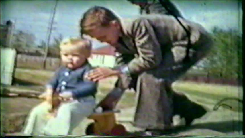 Three young siblings play together outdoors with a toy rocking horse in this charming 1950s vintage home movie