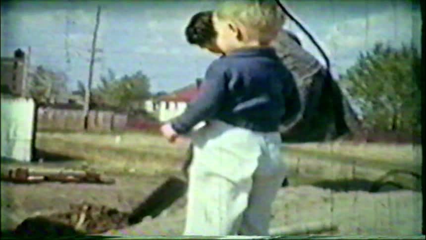 Nostalgic home movie from the 1950s captures a sweet moment of children playing in their backyard with their mother