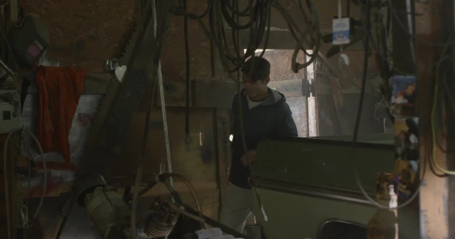 Man entering a cluttered garage from outdoors
