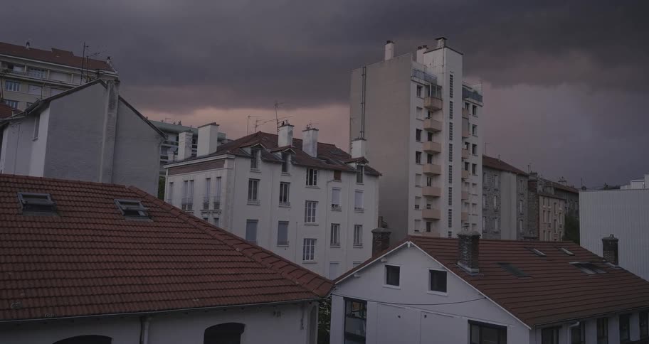 Lightning flashes across the sky during a thunderstorm over European city apartment buildings