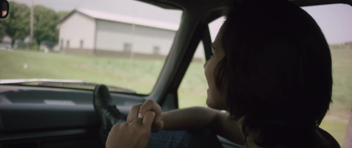 A woman smiles while riding in a car