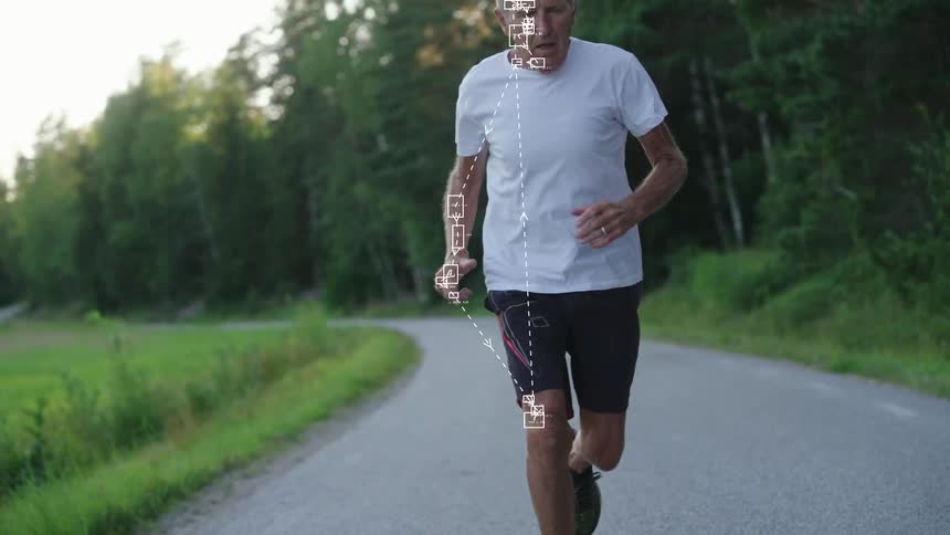 A senior man jogs on a country road while a futuristic digital overlay tracks and analyzes his biometrics and movements