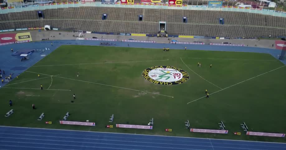 A group of runners are racing around a track in a stadium