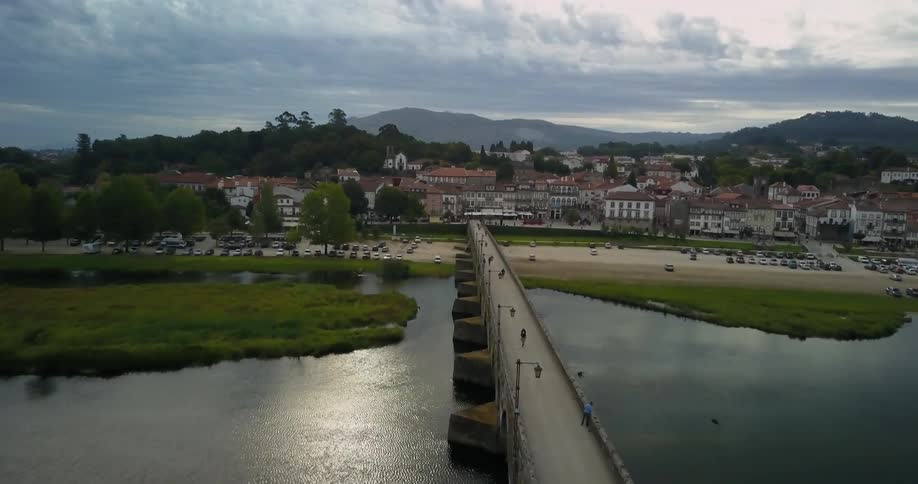 People walk across a bridge in town