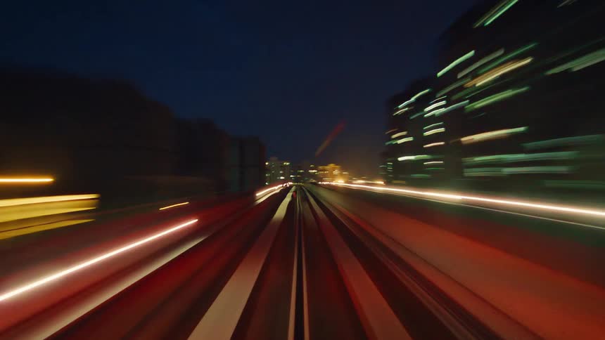 Futuristic POV time-lapse of a high-speed train journey at night, where urban lights blend into a symphony of colorful streaks