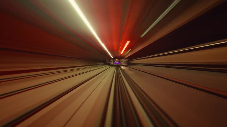 A mesmerizing abstract time-lapse from the front of a subway train speeding through a tunnel of vibrant, colorful light streaks