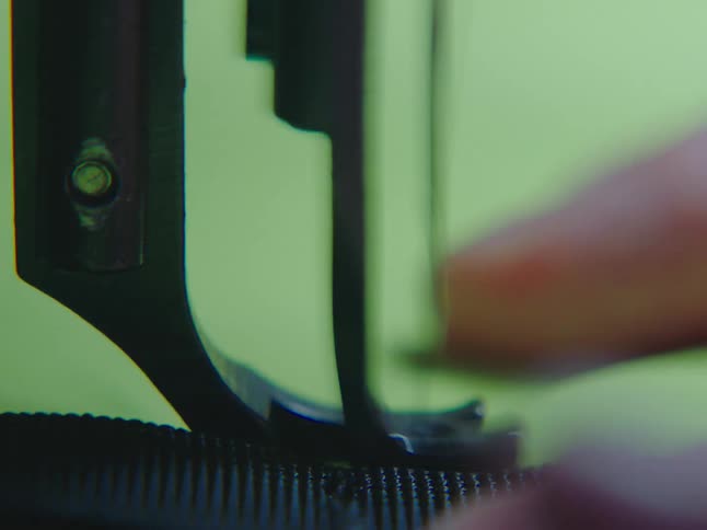 A detailed macro shot shows a sewing machine needle meticulously stitching through black fabric
